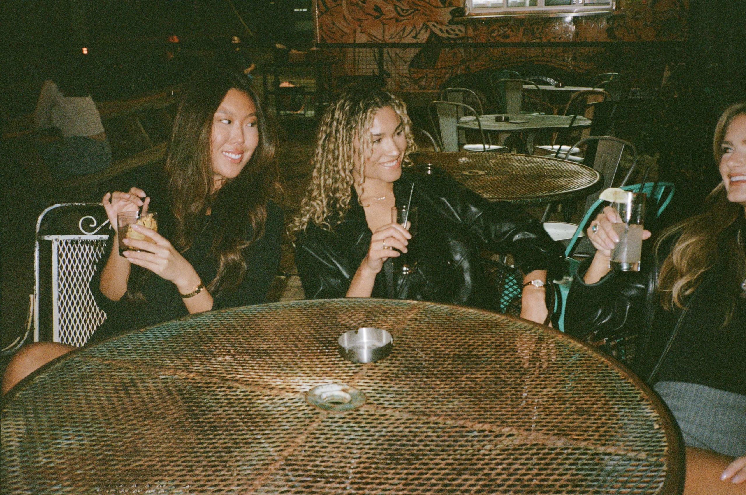 Women sitting at a table, getting drinks together
