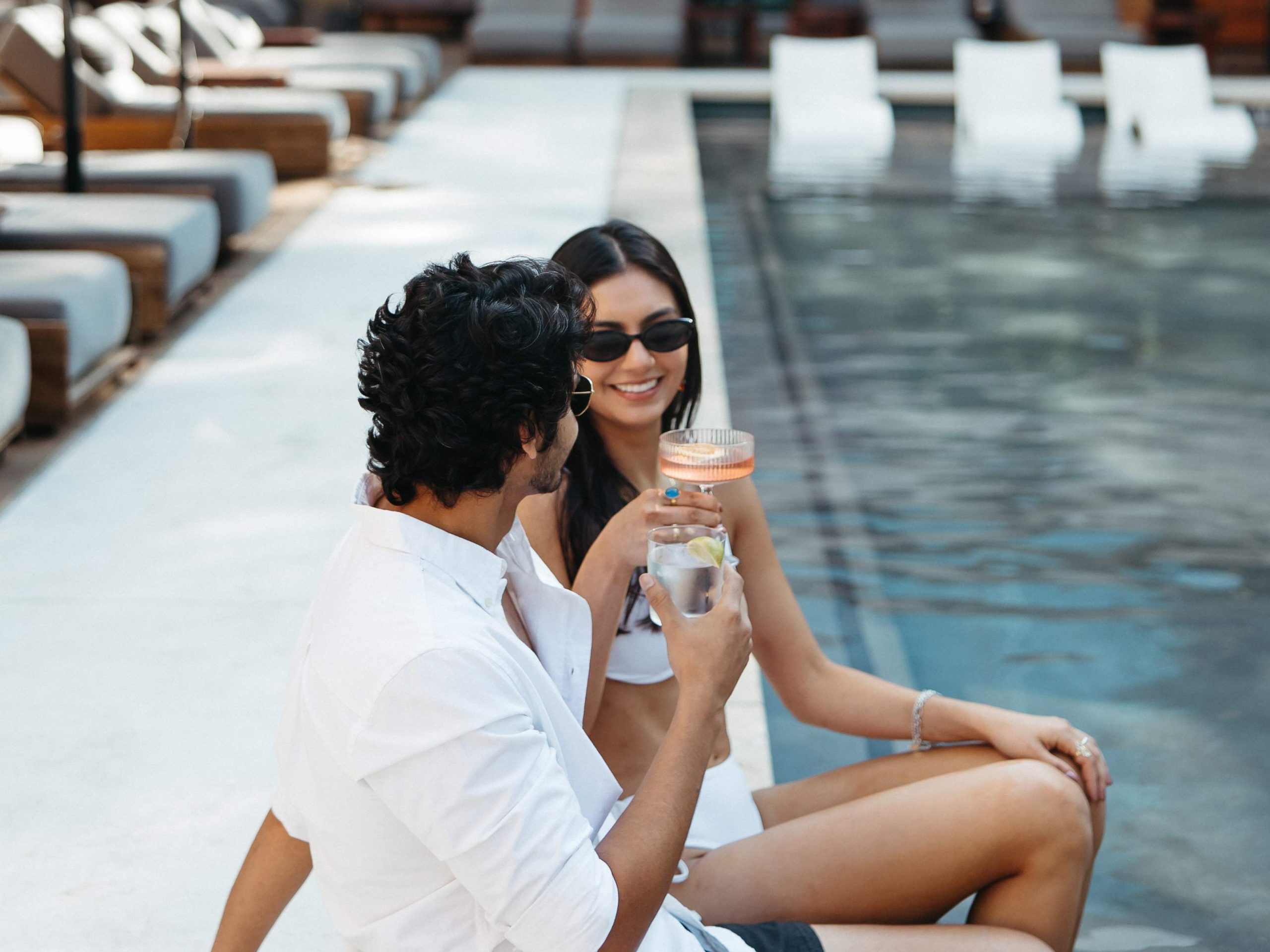 Two people having drinks by the pool