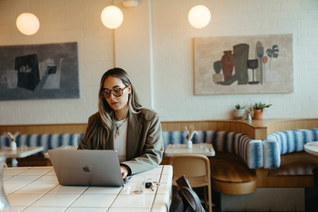 Girl working on laptop at coffee shop in downtown Austin