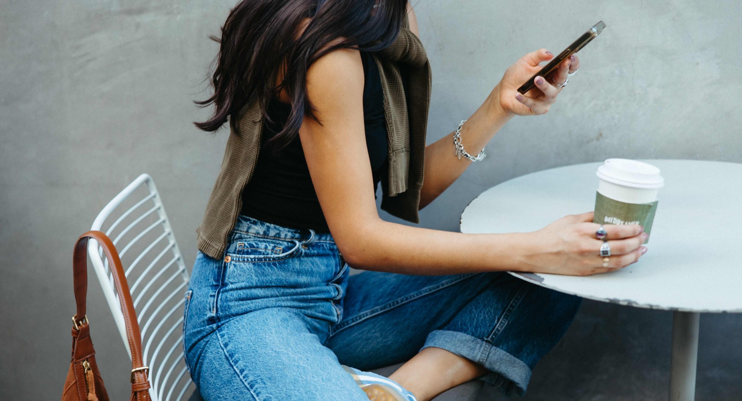 Girl on her phone at Paseo luxury apartments' daydreamer coffee shop.