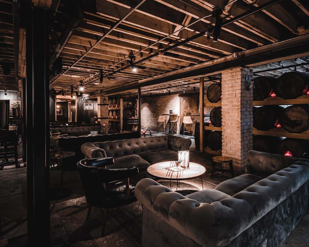 Cozy interior of Dumont’s Down Low, an underground Austin cocktail bar known for its whiskey selection.