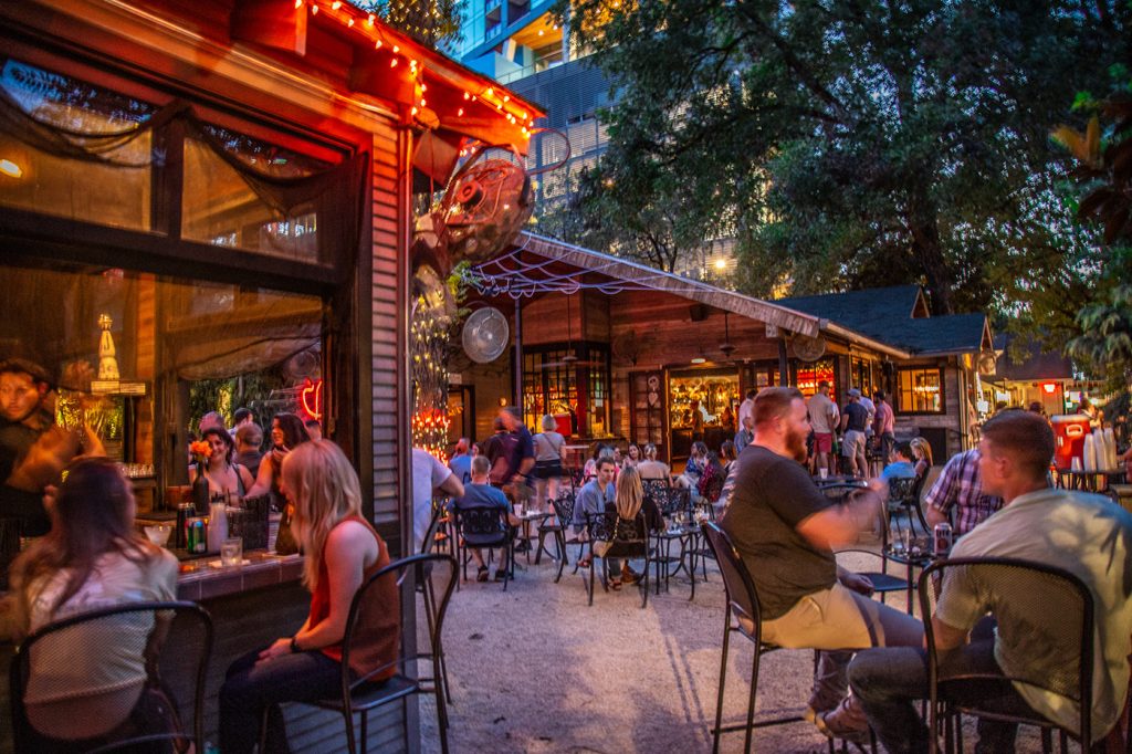 Crowds enjoying drinks at Lucille, one of the best cocktail bars in downtown Austin, with a lively patio atmosphere.