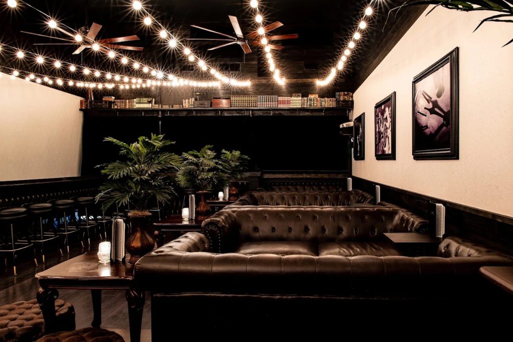 Lounge seating at The Roosevelt Room, one of the best cocktail bars in downtown Austin, under string lights.