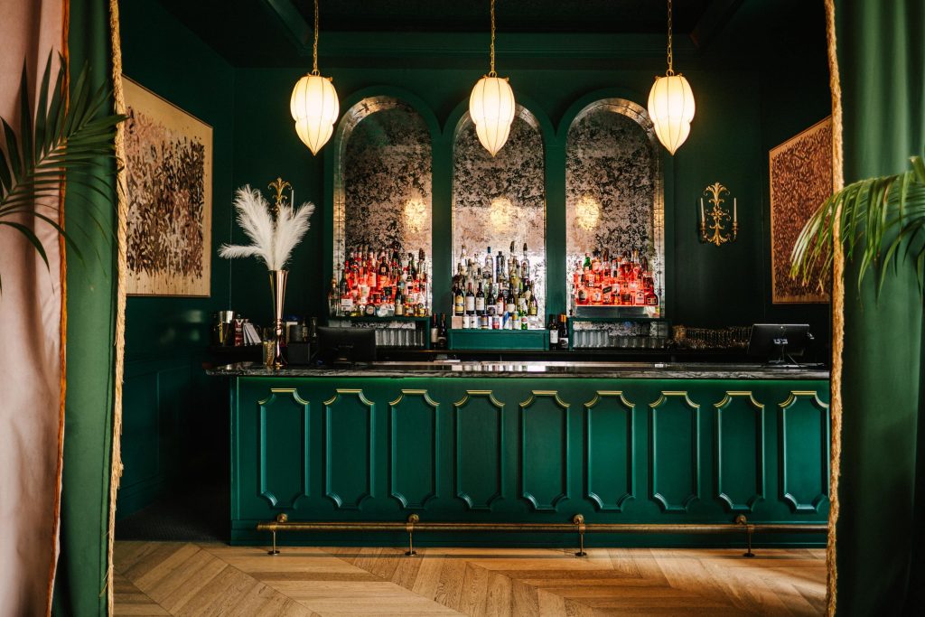 Green, eclectic interior at Tiger Lilly, one of the best downtown Austin cocktail bars.