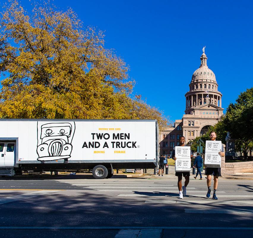  Two Men and a Truck crew, one of the best Austin moving companies, unloading in front of the Texas capital. 