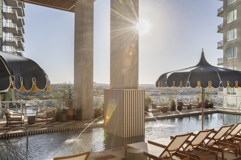Level 12 pool with lounge chairs, umbrellas, and open seating at Paseo in Downtown Austin.