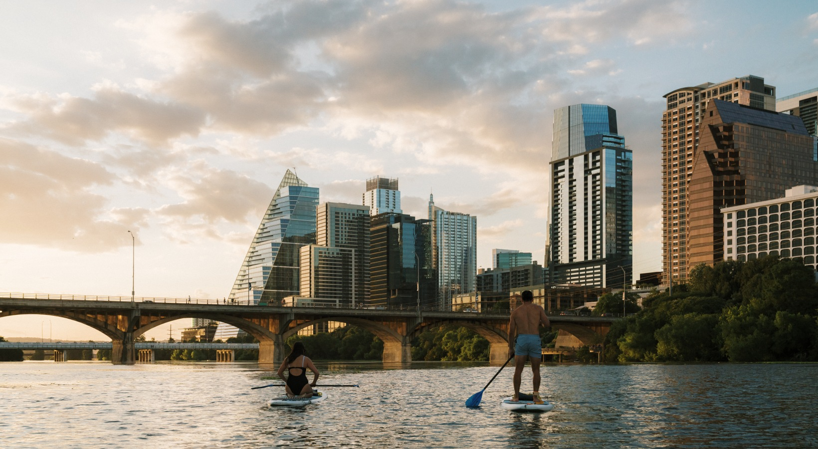 Two kayakers in downtown Austin near The Travis.